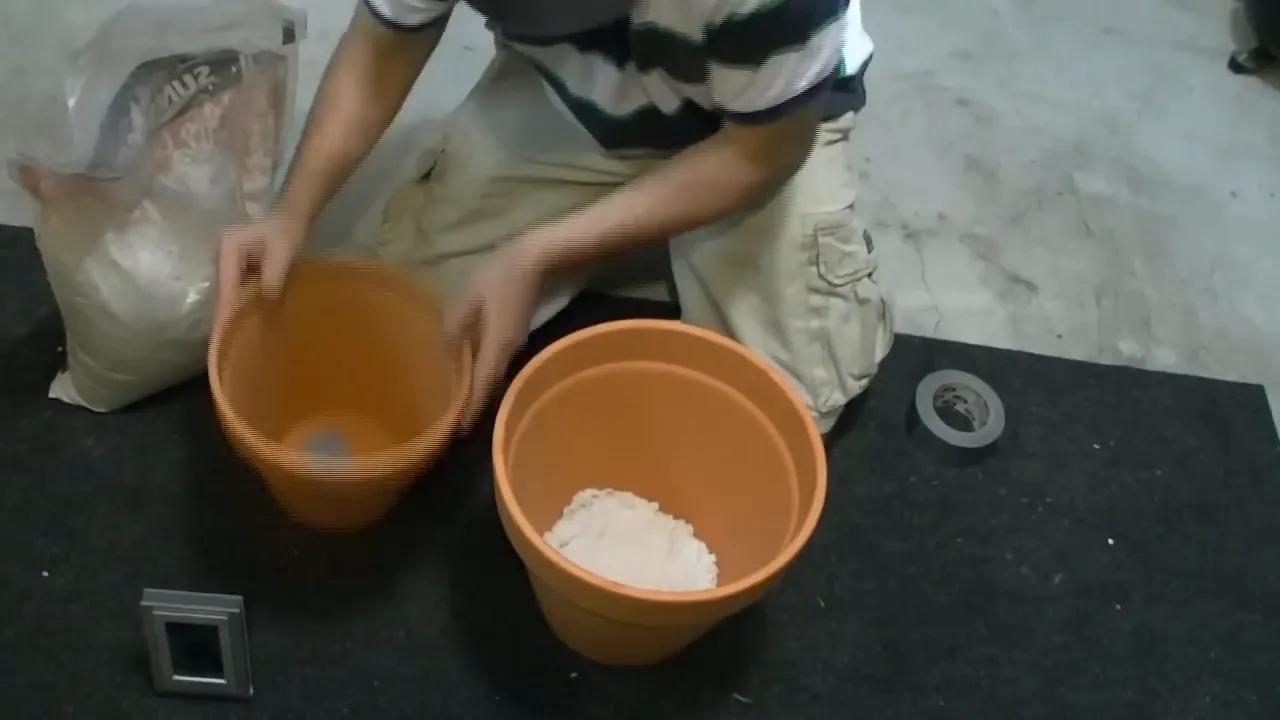 Filling the larger pot with sand